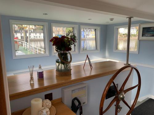 a room with a counter with a vase of flowers on it at The Barge Tarbert in Tarbert