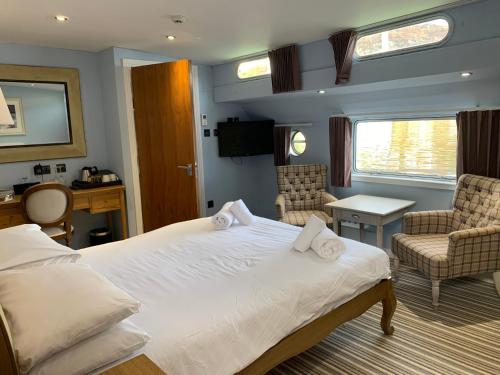a bedroom with a bed and chairs in a room at The Barge Tarbert in Tarbert