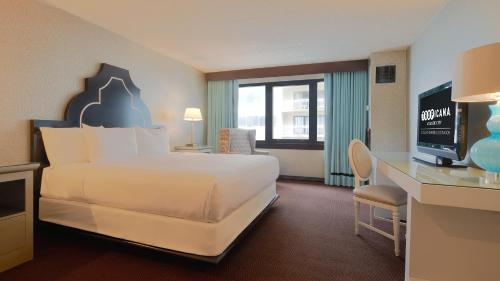 a hotel room with a large bed and a desk at Tropicana Atlantic City, A Caesars Destination in Atlantic City