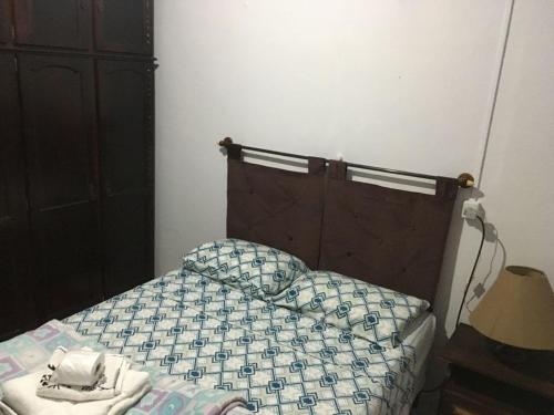 1 dormitorio con 1 cama con edredón azul y blanco en Morada do Estudante, en Pelotas