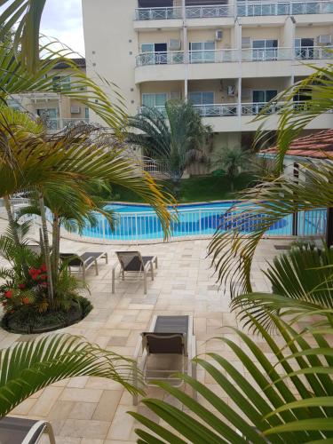 um pátio de hotel com piscina e palmeiras em Cobertura Loft-Jacuzzi-Piscina-Praias-Super Vista em Niterói