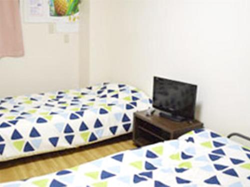 Ένα ή περισσότερα κρεβάτια σε δωμάτιο στο Guest House Fukutomi - Female Only