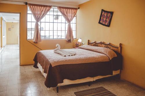 a bedroom with a bed with a large window at Hotel Shinula in Huehuetenango