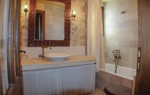 a bathroom with a sink and a mirror and a tub at Awesome Home In Aigio With 3 Bedrooms, Wifi And Outdoor Swimming Pool in Aigio