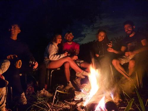 a group of people sitting around a fire at El Cielo Biohospedaje - Refugio Sostenible en la Naturaleza in Tena