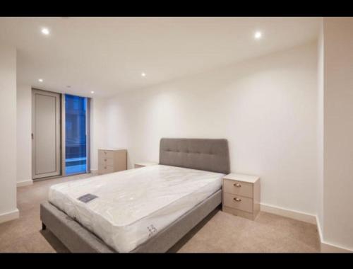 a white bedroom with a large bed and a window at Luxurious Manchester City Centre 2 Bed Apartment in Manchester