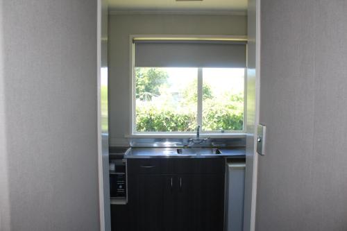 une cuisine avec un évier et une fenêtre dans l'établissement Aorangi Motel, à Fairlie