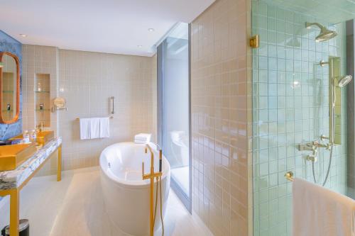 a bathroom with a shower and a toilet and a sink at Hotel Indigo Bangkok Wireless Road by IHG in Bangkok