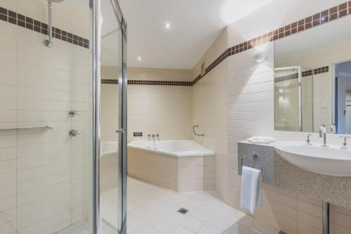 a bathroom with a shower and a sink and a tub at Nightelier Mermaid Waters in Gold Coast