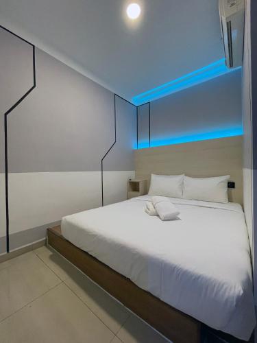 a bedroom with a white bed with a blue ceiling at GG Hotel Bandar Sunway in Petaling Jaya