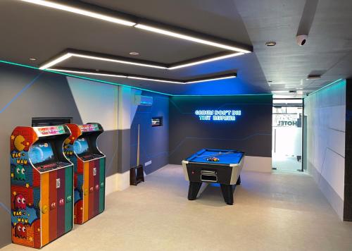 a room with two arcade games and a pool table at GG Hotel Bandar Sunway in Petaling Jaya