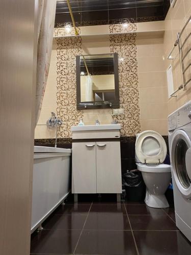 a bathroom with a sink toilet and a washing machine at Аэропорт in Irkutsk