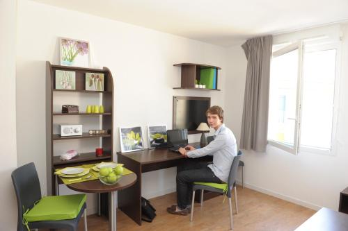 a man sitting at a desk with a computer at Central Fac in Bourg-en-Bresse