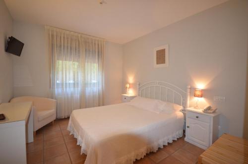 a bedroom with a white bed and a window at Hotel Rural Seixalvo in Sanxenxo