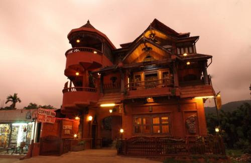 a large wooden building with a tower at Coffee Inn in Thekkady