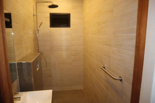 uma casa de banho com um chuveiro e um lavatório. em Empire Apartments SU 2 Marthastraat em Paramaribo