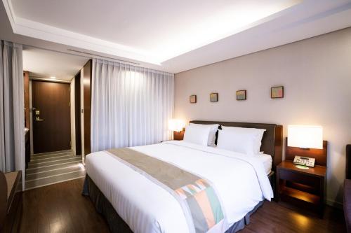 a large white bed in a hotel room at Seoul Garden Hotel in Seoul