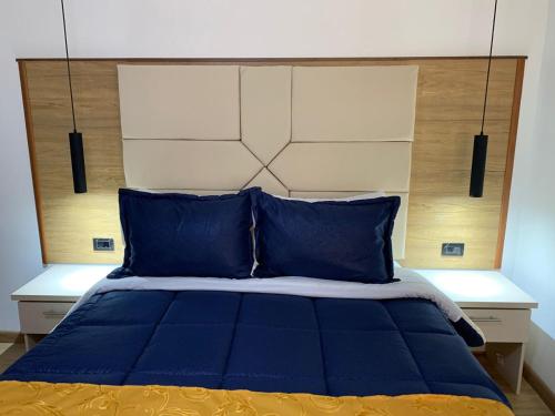 a bed with blue pillows and a large headboard at Hotel Casa Modelia in Bogotá