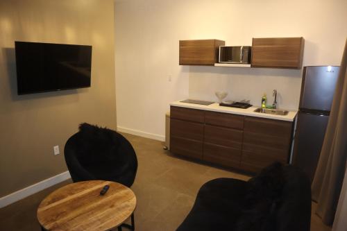 a small kitchen with a table and a refrigerator at Empire Apartments SU 2 Marthastraat in Paramaribo