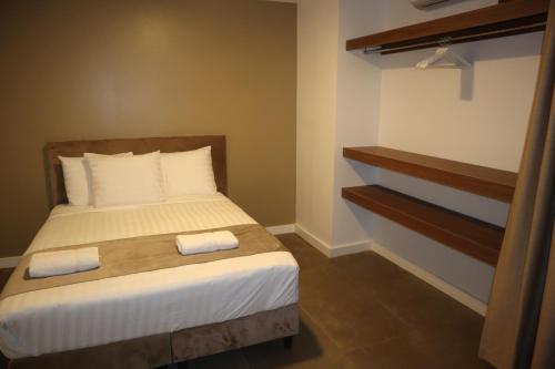 a bedroom with a bed with two towels on it at Empire Apartments SU 2 Marthastraat in Paramaribo