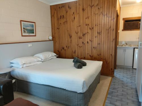 a bedroom with a bed with a teddy bear on it at Yarragon Motel in Yarragon