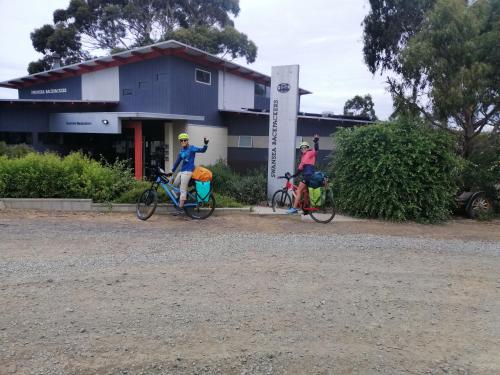 two people on bikes in front of a building at Swansea Backpackers in Swansea
