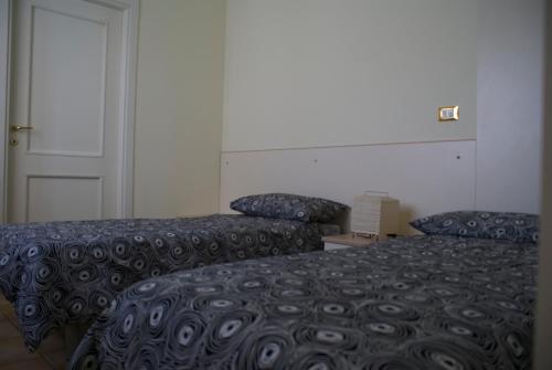 pokój hotelowy z 2 łóżkami i drzwiami w obiekcie Olly Apartments w Bolonii