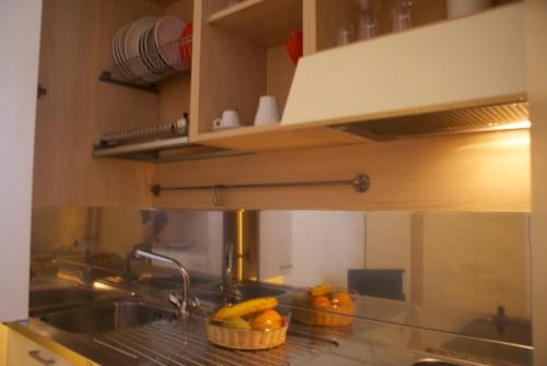 kuchnia ze zlewem i pomarańczami na ladzie w obiekcie Olly Apartments w Bolonii