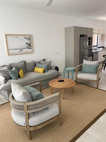 a living room with a couch and a table at Eastern Blue Beachfront Luxury Apartment in Poste Lafayette