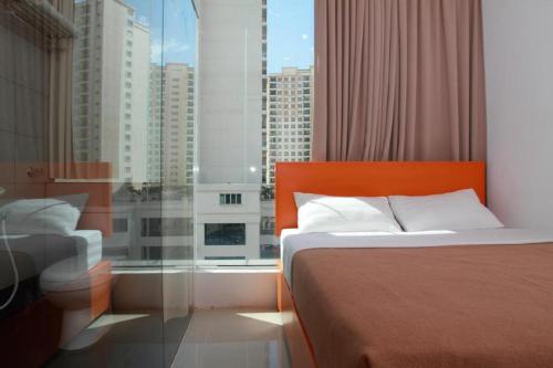 a bedroom with a bed and a large window at 1 Hotel Kuchai Lama in Kuala Lumpur