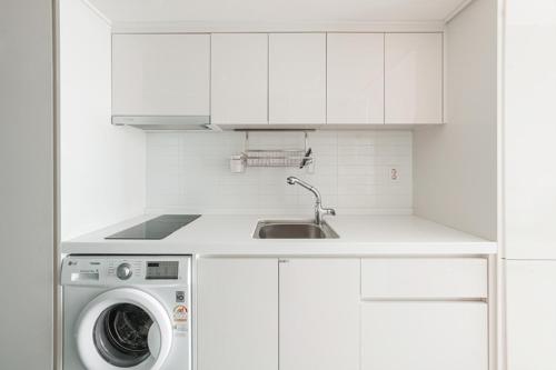 a white kitchen with a sink and a washing machine at Blue Ocean Residence Hotel in Incheon