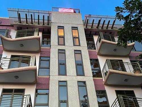 a tall apartment building with balconies on it at Jaffa Suites in Kampala