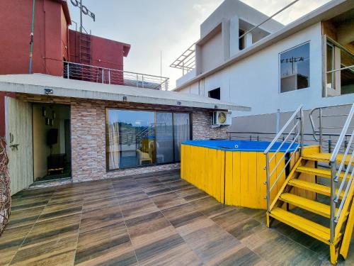 a balcony with a yellow and blue table on a building at Pooja Villa Suites-Rooms and Pool, Igatpuri in Igatpuri