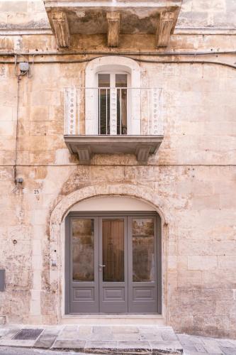 a stone building with a door and a window at Via Roma 32 in Ostuni