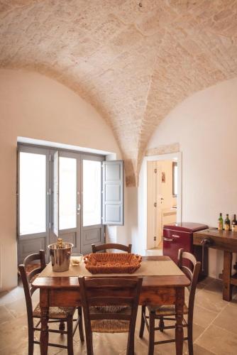 a dining room with a wooden table and chairs at Via Roma 32 in Ostuni