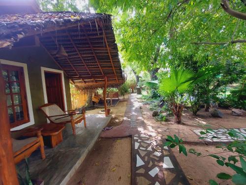 a house with a table and a bench in front of it at Inn On The Bay in Pasikuda