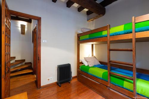a room with bunk beds and a hallway with a staircase at Cal Cambrot in Bagá