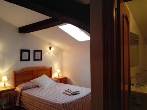 a bedroom with a bed and a skylight at La Posada Nueva in Viscarret-Guerendiáin