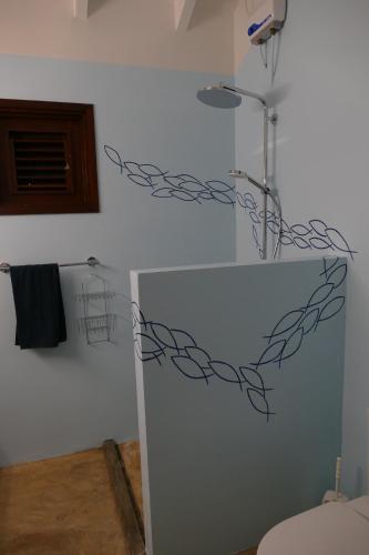 a bathroom with a white wall with a wire sculpture on the wall at Villa de Mango in Fontein