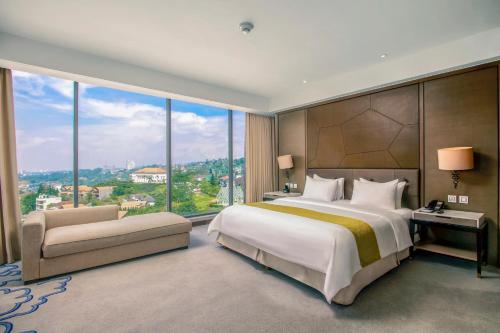 a bedroom with a large bed and a large window at InterContinental Bandung Dago Pakar by IHG in Bandung