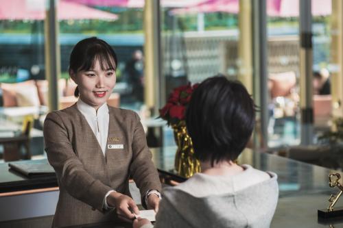 a woman talking to a woman in a restaurant at Mumian Chengdu Dong'an Lake in Chengdu
