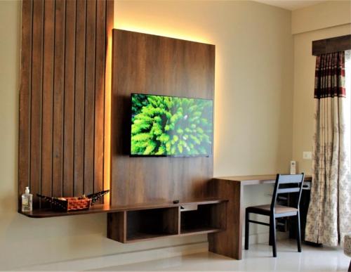 Una sala de estar con un televisor en la pared. en The Nest Holiday home, en Marmagao