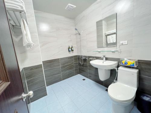 a bathroom with a toilet and a sink and a shower at Mu Travel B&B in Kenting