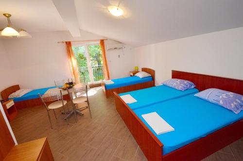 a room with two beds and a table in it at Apartments Scorpio in Kotor