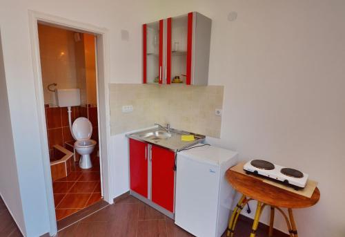 a small kitchen with a sink and red cabinets at Apartments Scorpio in Kotor
