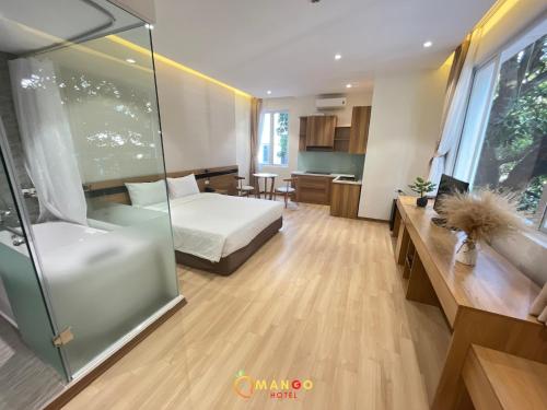 a bedroom with a bed and a glass shower at Mango Hotel - Ha Noi Railway station in Hanoi