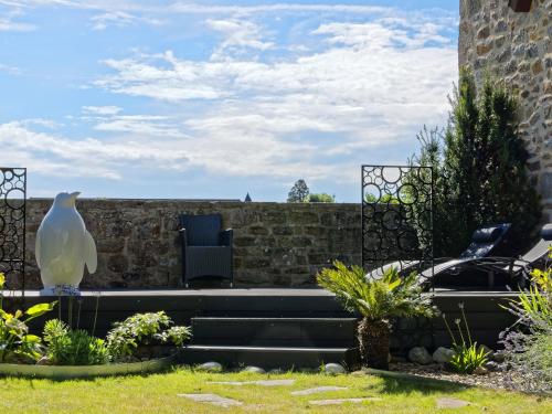 a garden with a white bird sitting on the stairs at Le 27- Boutique B&B in Dinan