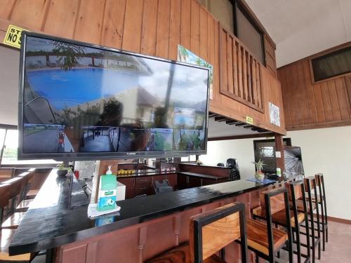uma grande televisão de ecrã plano em cima de um bar em Heidi Sanctuary Resort by Cocotel em Angeles