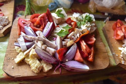 a wooden cutting board topped with vegetables on a table at Cabana „Stâna din Deal” in Proviţa de Sus