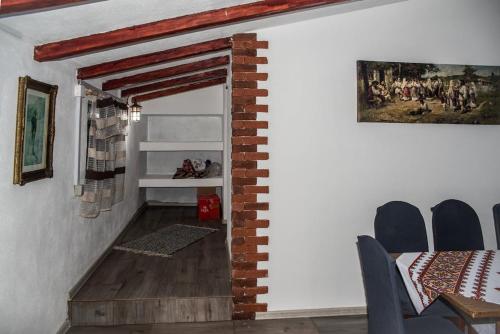 a dining room with a table and chairs and a brick wall at Cabana „Stâna din Deal” in Proviţa de Sus